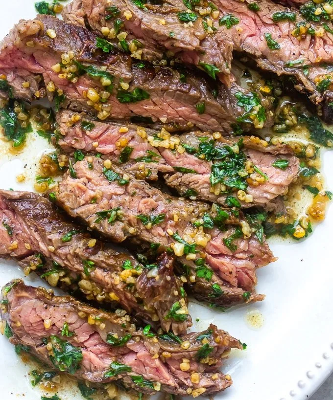 Delicious Brazilian steak topped with garlic butter on a grill plate