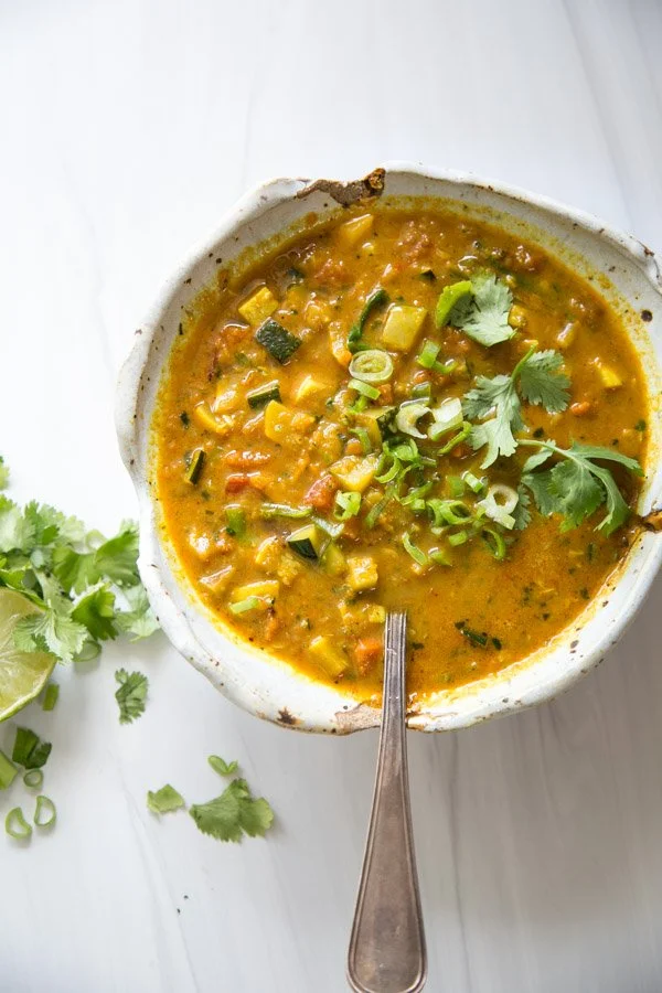 Bowl of low FODMAP vegan veggie detox soup with colorful vegetables.