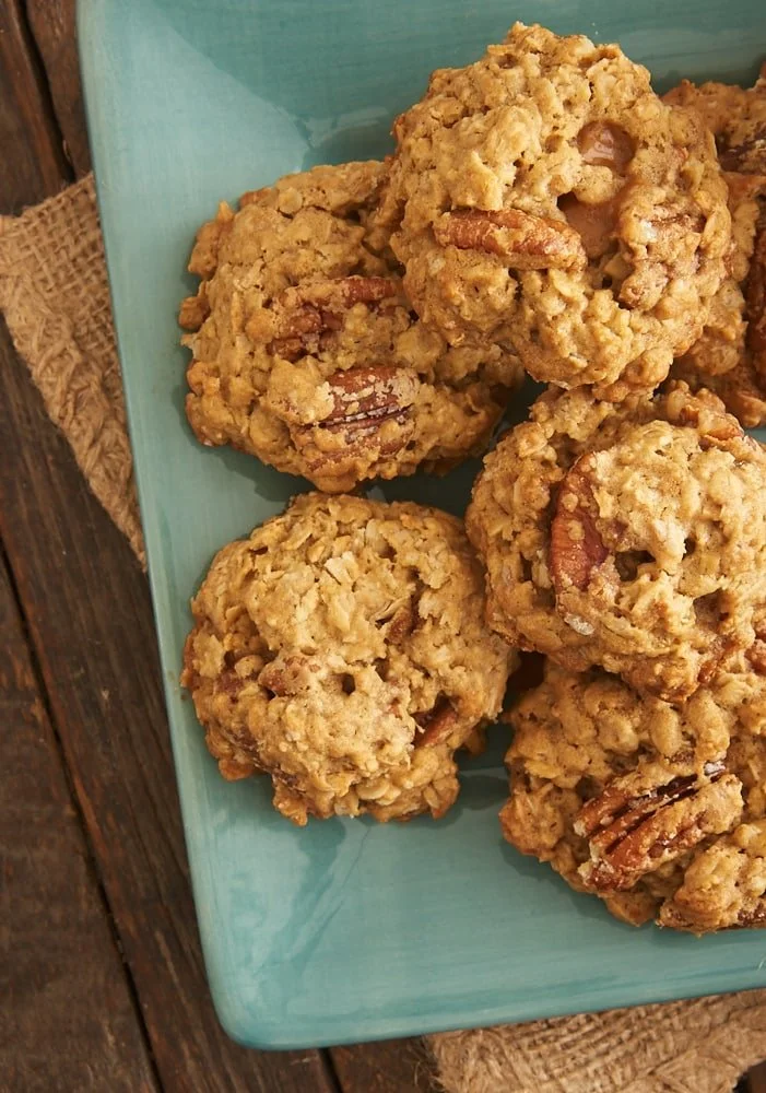 Freshly baked oatmeal cookies with buttered pecans on a cooling rack