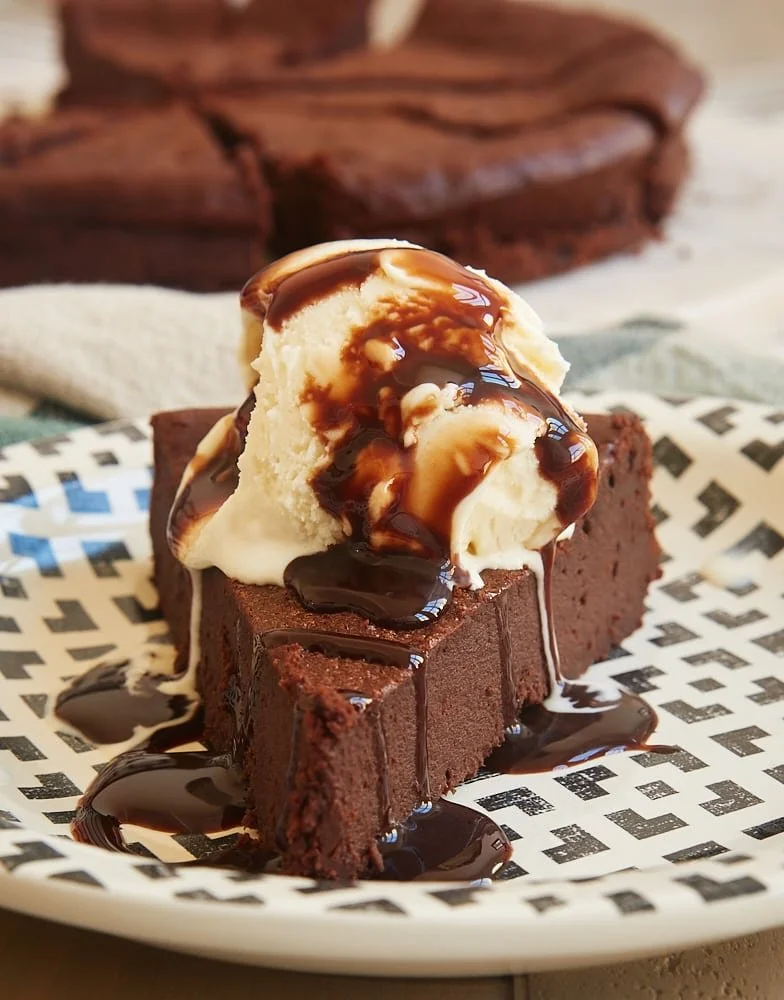 A decadent homemade simple chocolate torte served on a elegant plate.